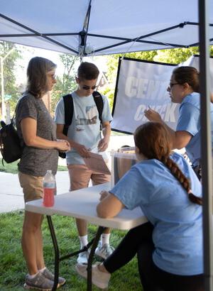 Two residential education staff members help a male first-year student and mother navigate the move -in process